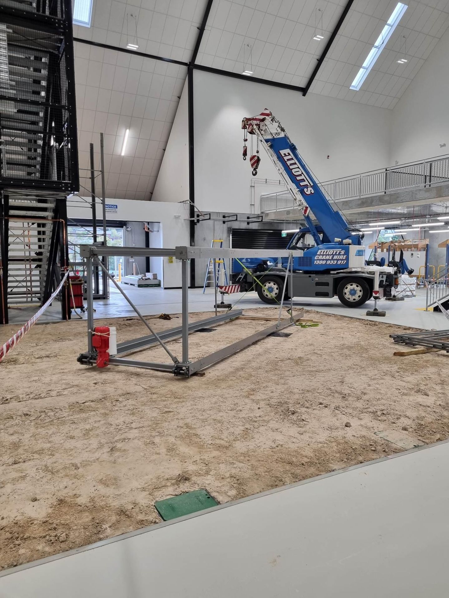 Crane lifting the goods lift base frame into position