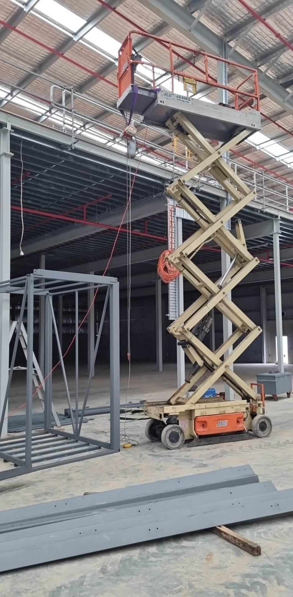 Scissor lift raised alongside the shaft columns